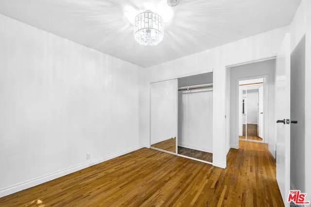 a view of a room with wooden floor and a ceiling fan