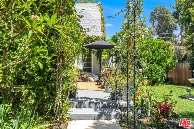 a view of a garden with a bench and some plants
