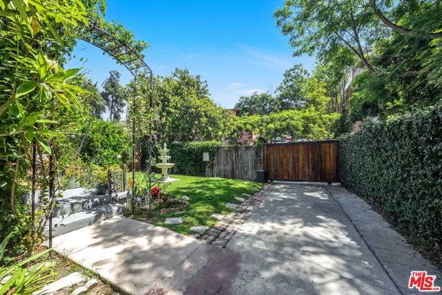 a view of backyard with table and chairs and a large tree
