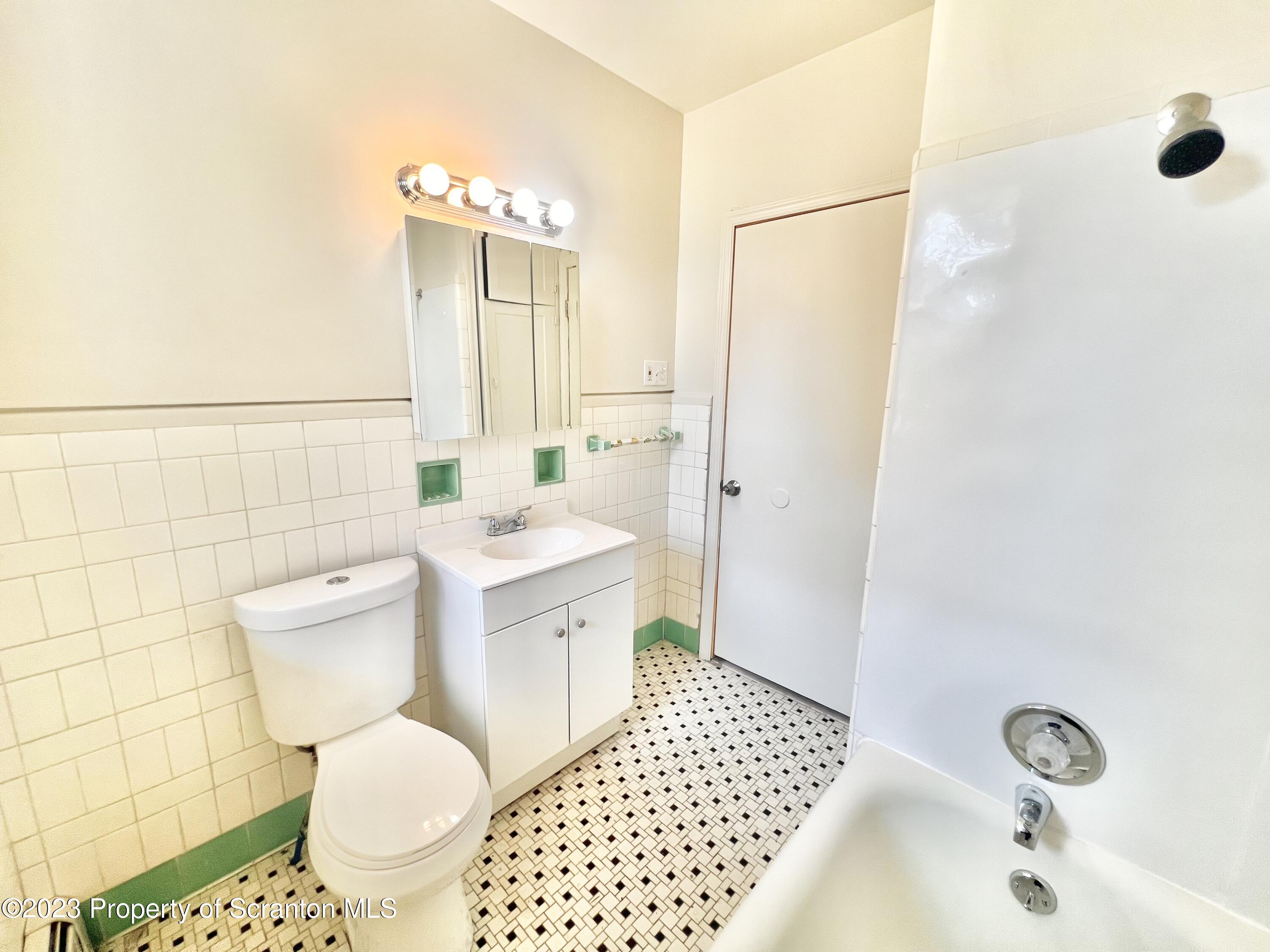 1930 Boulevard Avenue, Unit 1 Scranton, PA 18509 - Photo 4 of 9 a bathroom with a sink toilet a mirror and shower
