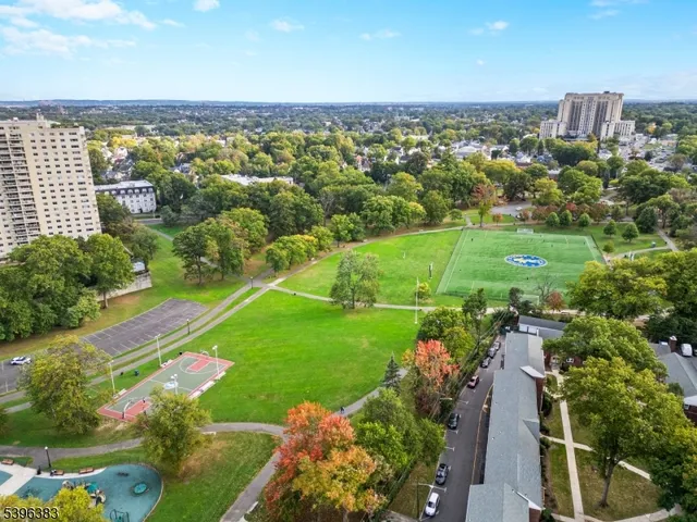 an aerial view of a city with lots of residential buildings ocean and mountain view in back