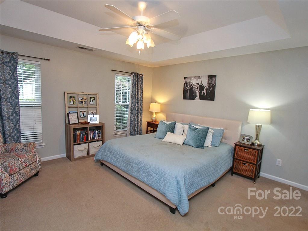 2011 Fairburn Court Fort Mill, SC 29708 - Photo 23 of 29 a bedroom with a large bed and a chandelier