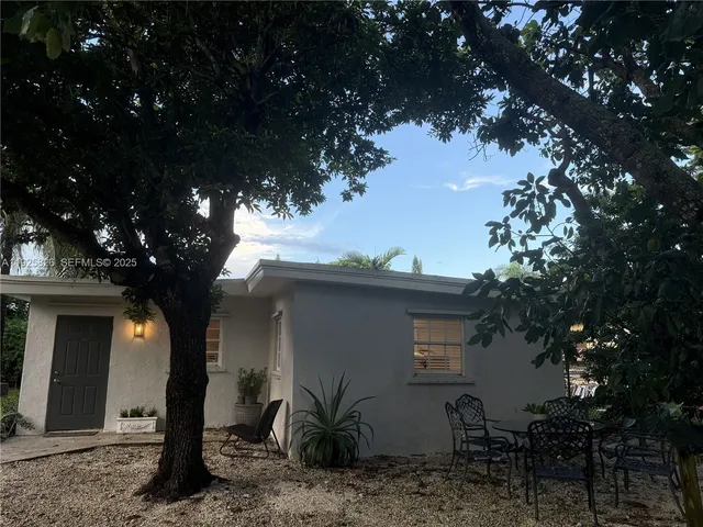 a view of a wooden house with a tree