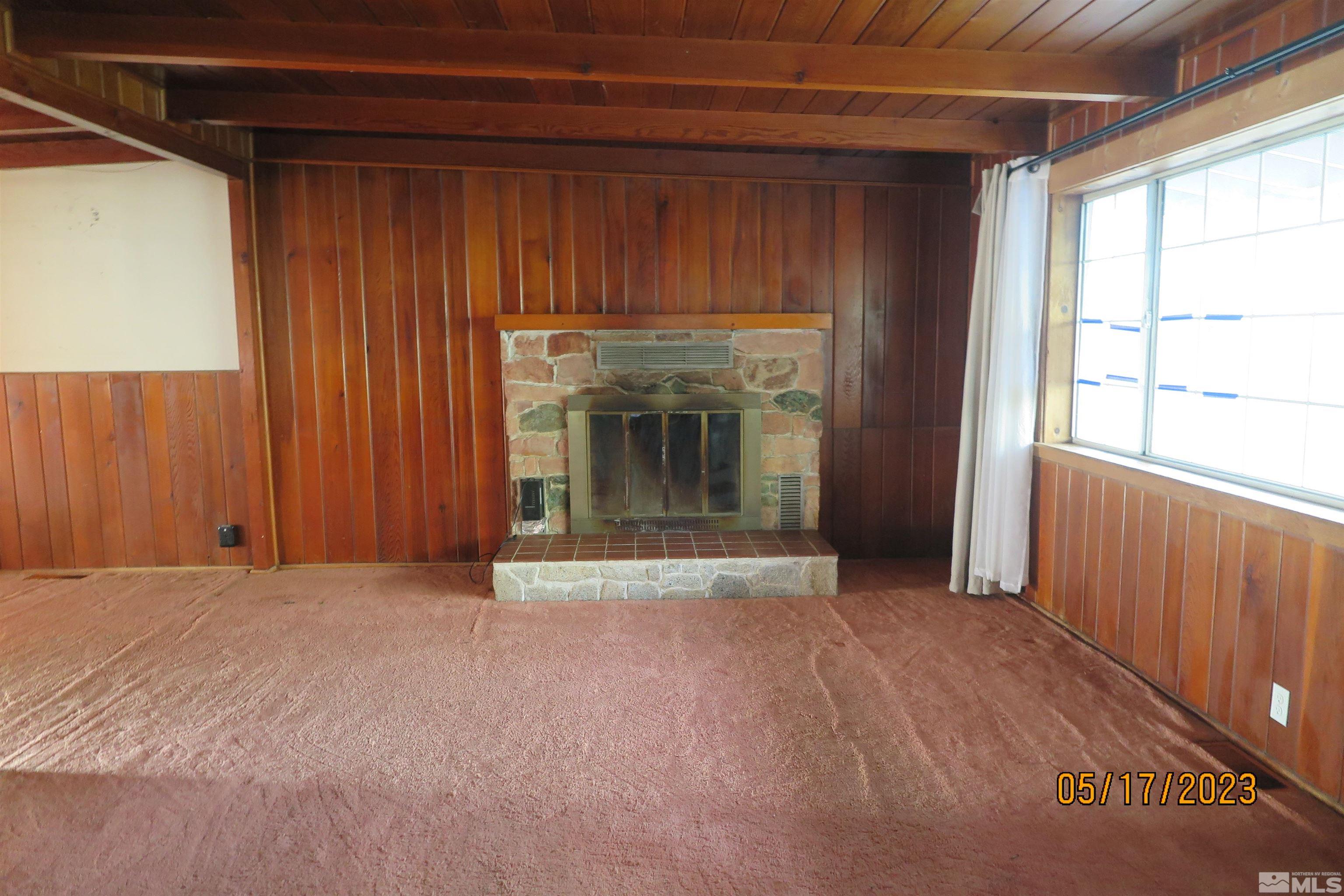 208 Rhodes Road Reno, NV 89521 - Photo 13 of 33 a view of an empty room with a fireplace and a window