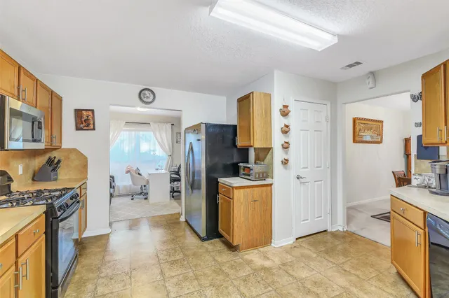 a kitchen with stainless steel appliances a refrigerator and a stove top oven