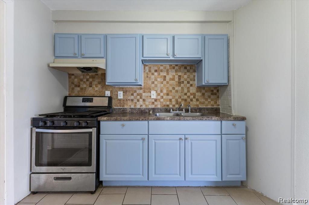 26076 Colgate Street Inkster, MI 48141 - Photo 7 of 24 Kitchen featuring blue cabinetry, a stainless steel range, a mosaic tile backsplash, and a double basin sink