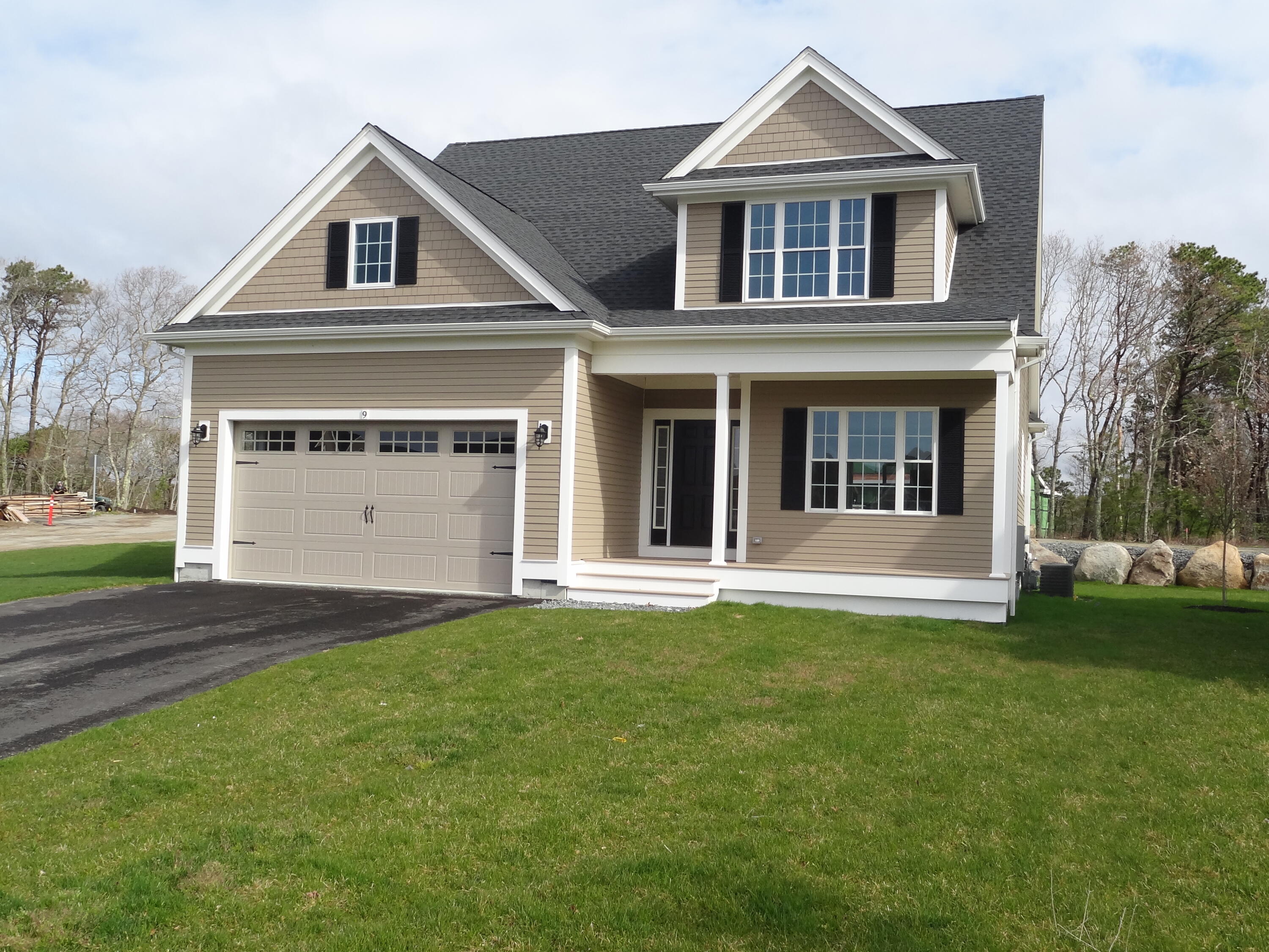 9 Cpe Clb Road East Falmouth, MA 02536 - Photo 4 of 58 a front view of a house with a yard and garage