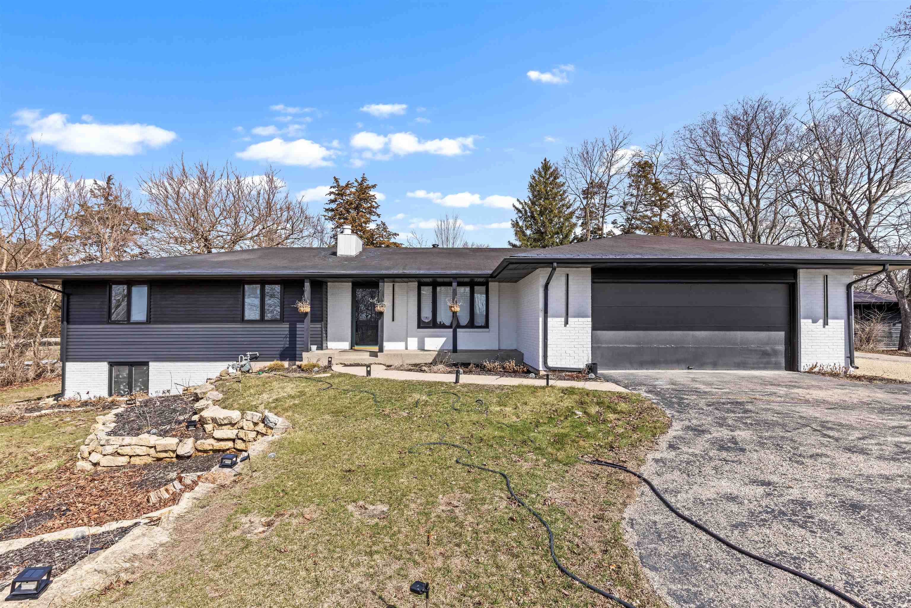 a front view of a house with a yard and seating space