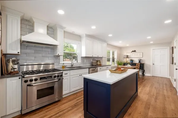 a kitchen with a refrigerator and a stove top oven