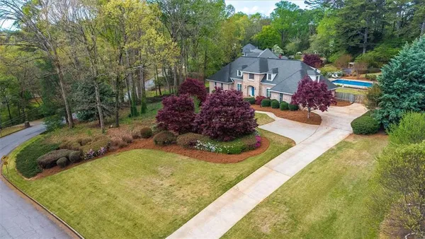 a front view of a house with a yard and trees