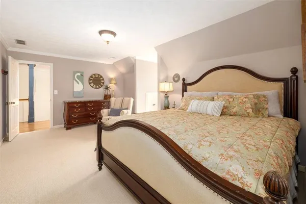 a spacious bedroom with a bed and a chandelier