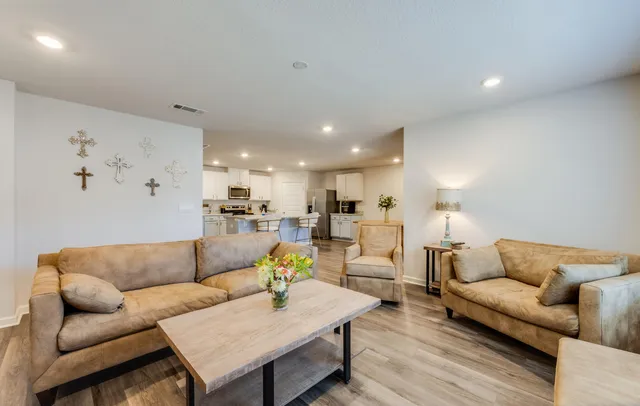 a living room with furniture and kitchen view