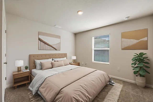 a bedroom with a bed potted plant and a window