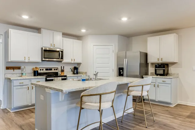 a kitchen with stainless steel appliances a stove top oven a refrigerator a sink and a refrigerator