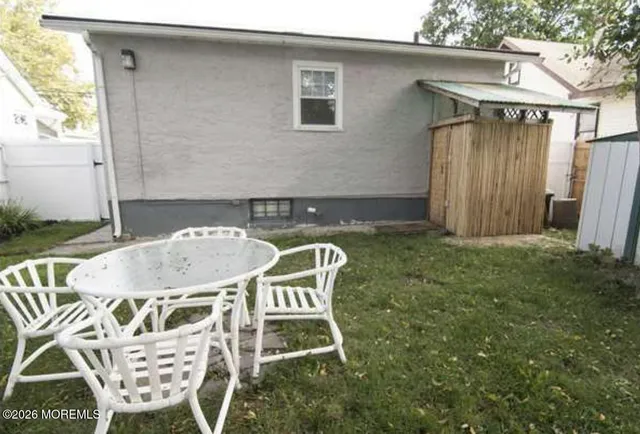 a backyard of a house with table and chairs