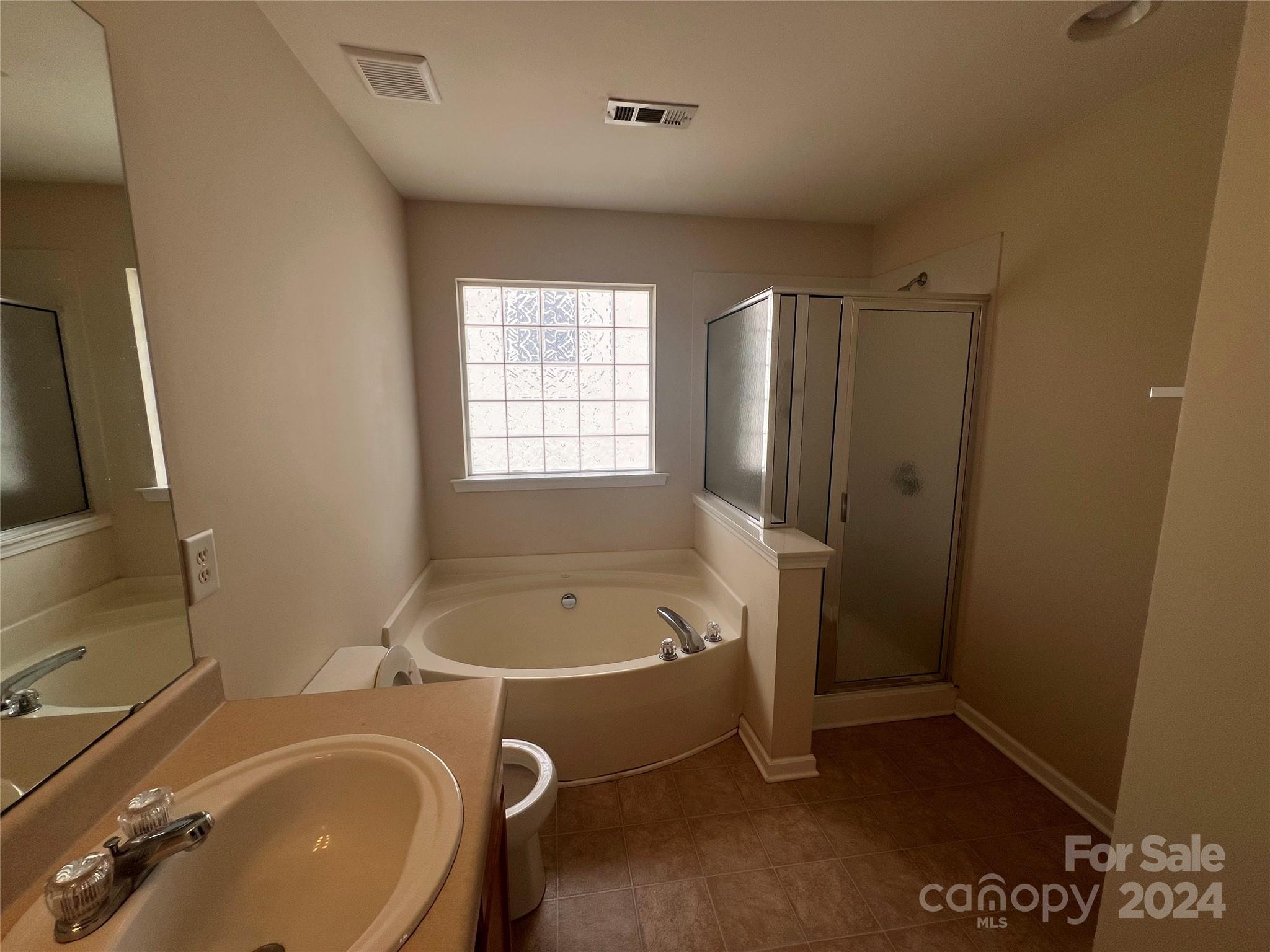 6702 Ferrell Commons Road Charlotte, NC 28269 - Photo 18 of 20 a bathroom with a tub a sink and a window