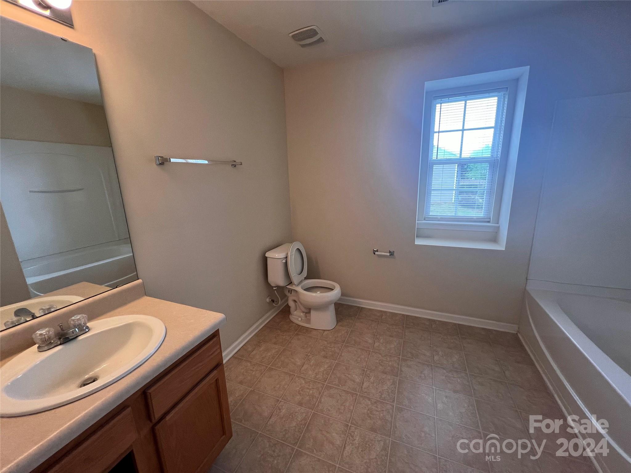 6702 Ferrell Commons Road Charlotte, NC 28269 - Photo 19 of 20 a bathroom with a sink toilet and a window