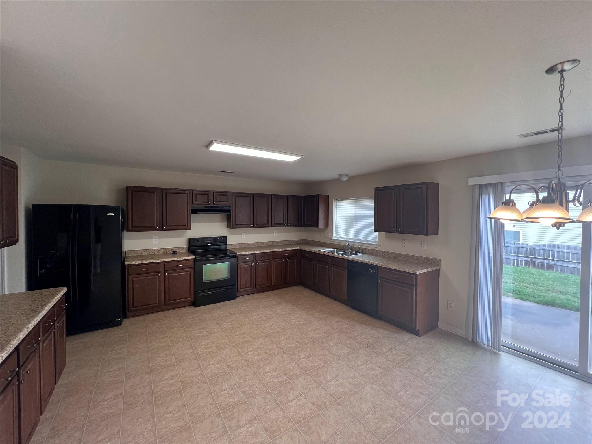 6702 Ferrell Commons Road Charlotte, NC 28269 - Photo 5 of 20 a kitchen with stainless steel appliances kitchen island granite countertop a refrigerator and a stove