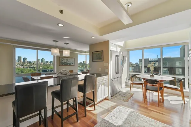 a kitchen with stainless steel appliances granite countertop table chairs and a view of living room