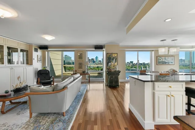 a living room with furniture a large window and wooden floor