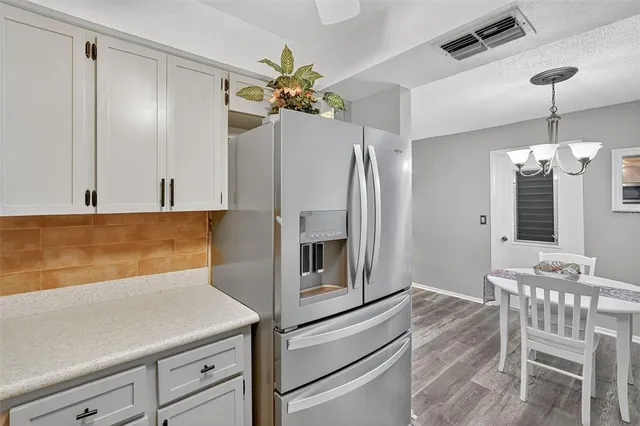 a kitchen with a refrigerator and chandelier