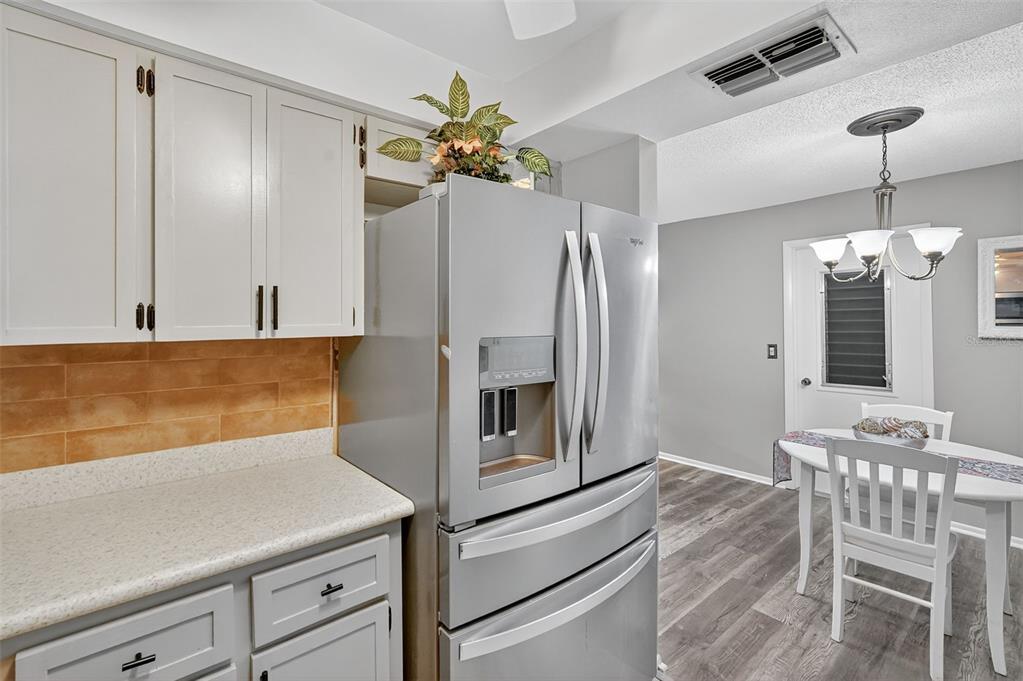 2320 Shelly Drive, Unit B Palm Harbor, FL 34684 - Photo 17 of 30 a kitchen with a refrigerator and chandelier