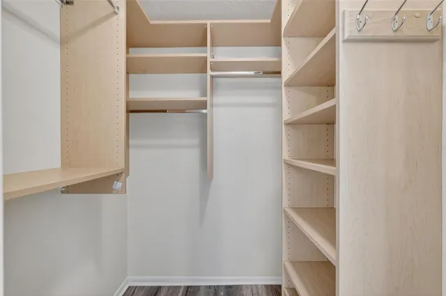a view of walk in closet with empty racks