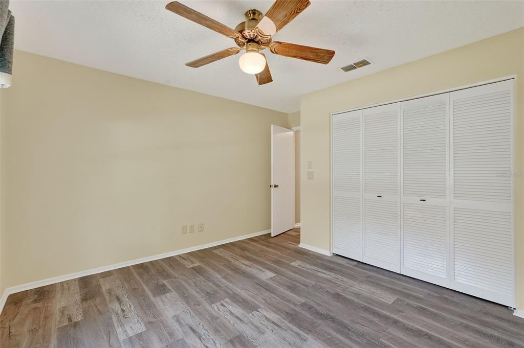 2320 Shelly Drive, Unit B Palm Harbor, FL 34684 - Photo 26 of 30 a view of a room with wooden floor and a ceiling fan