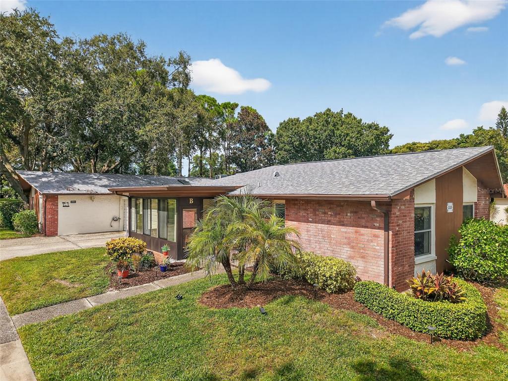 2320 Shelly Drive, Unit B Palm Harbor, FL 34684 - Photo 3 of 30 a view of a house with a yard and a garden