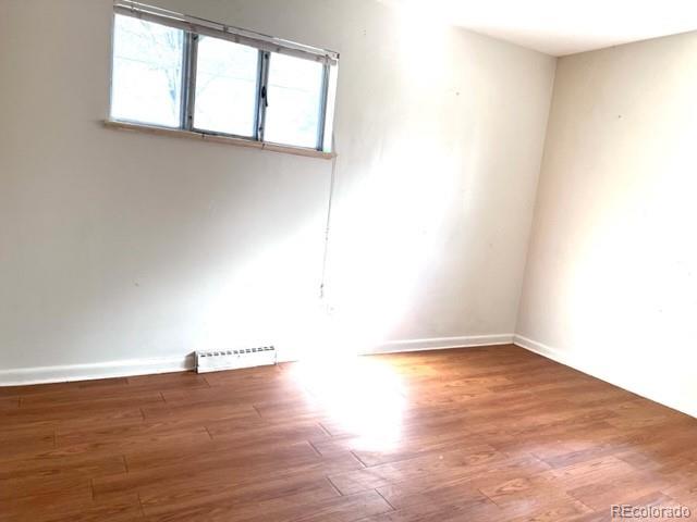 8640 Cherry Lane Westminster, CO 80031 - Photo 7 of 11 an empty room with wooden floor and windows