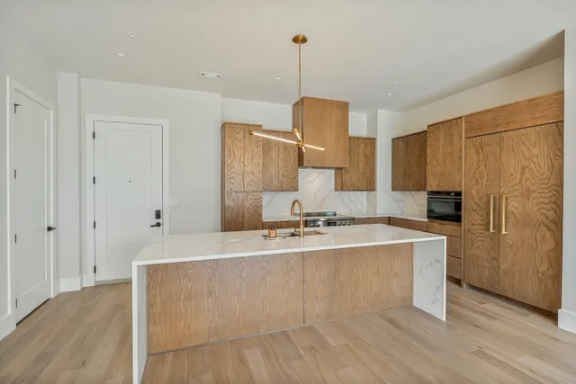 a large kitchen with kitchen island a sink a stove a refrigerator and a cabinets
