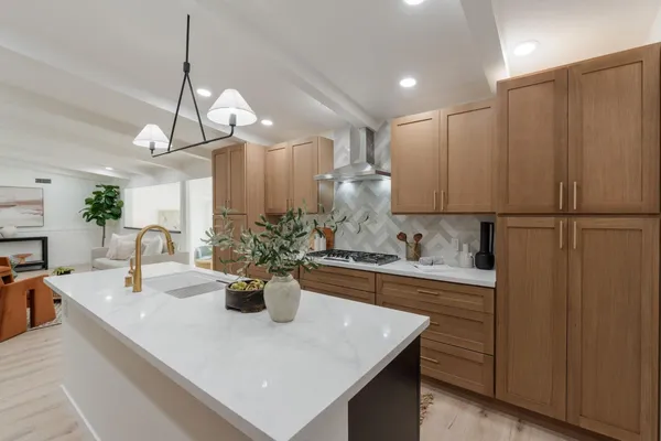 a view of a kitchen with kitchen island a sink and wooden floor