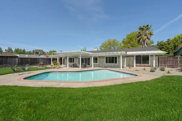 a view of house with swimming pool and porch