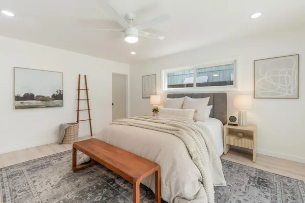 a bedroom with a bed and a painting on the wall