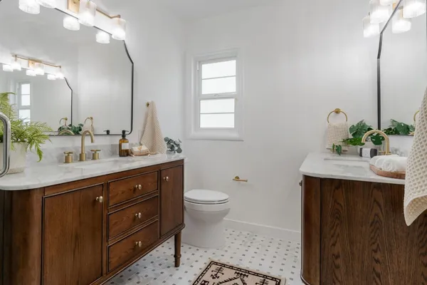 a bathroom with a sink a toilet and a mirror