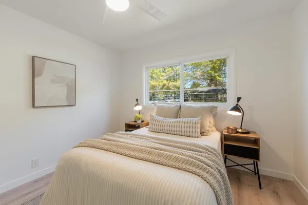 a bedroom with a bed and a lamp on table