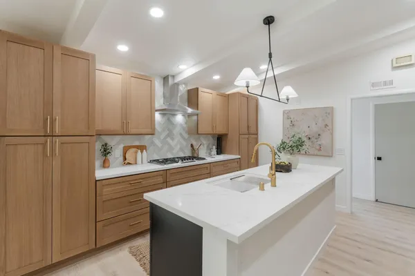 a large kitchen with kitchen island a sink stainless steel appliances and cabinets