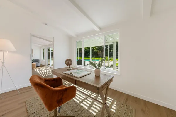 a dining room with furniture and a large window