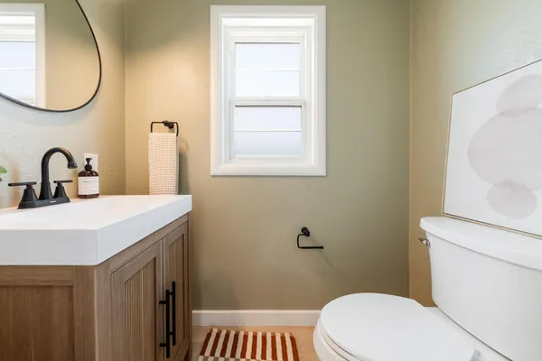 a bathroom with a sink a toilet and a mirror