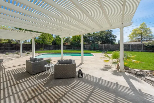a view of swimming pool with garden and patio