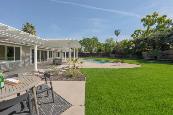 a view of a house with swimming pool and a yard