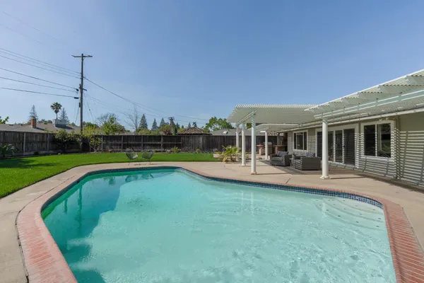 a view of a house with swimming pool and sitting area