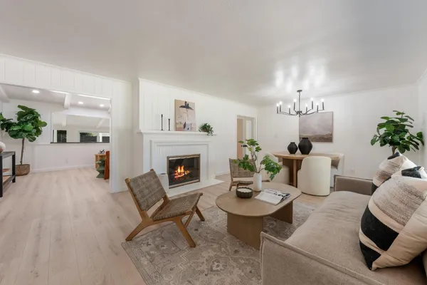 a living room with furniture a chandelier and a fireplace
