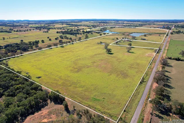an aerial view of a swimming pool with outdoor seating