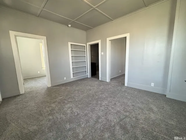 an empty room with closet and a ceiling fan