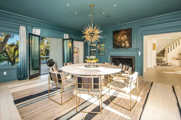 a dining room with furniture a floor to ceiling window and garden view