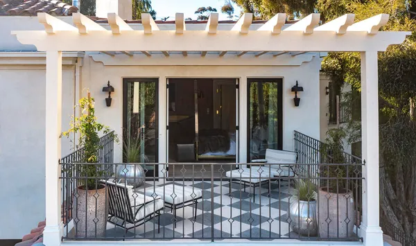 front view of house with two chairs and a potted plant