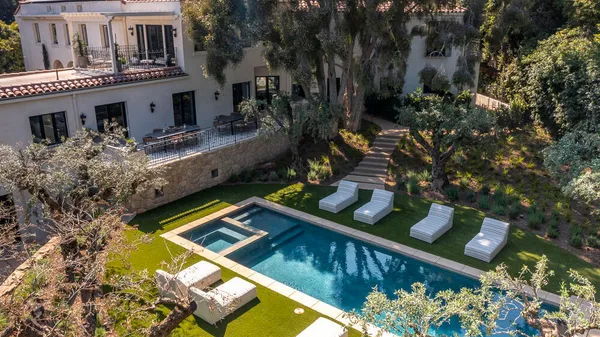 an aerial view of a house with swimming pool and furniture