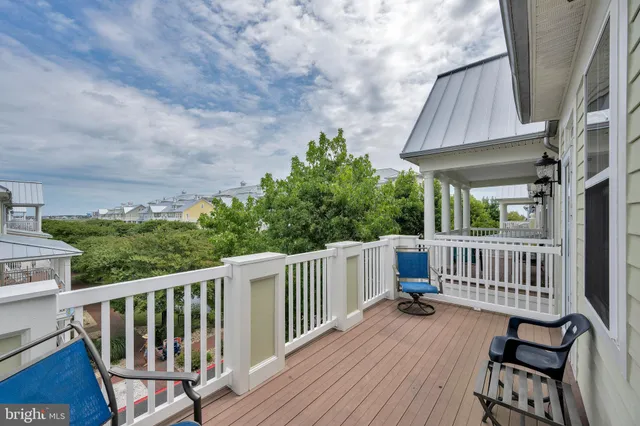a view of a house with wooden deck and furniture