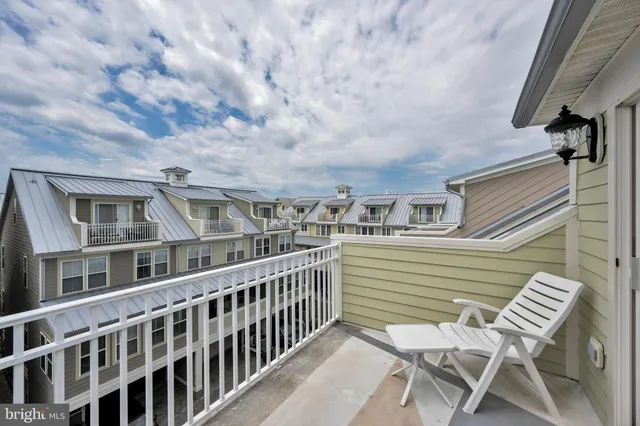 a view of a patio with table and chairs with wooden floor and fence